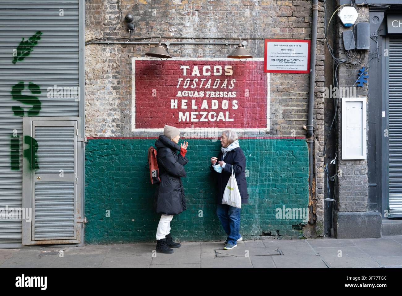 Zwei Frauen unterhalten sich auf der Stoney Street am Londoner Borough Market, der während der Coronavirus-Lockdown für Grundbedürfnisse geöffnet blieb Stockfoto