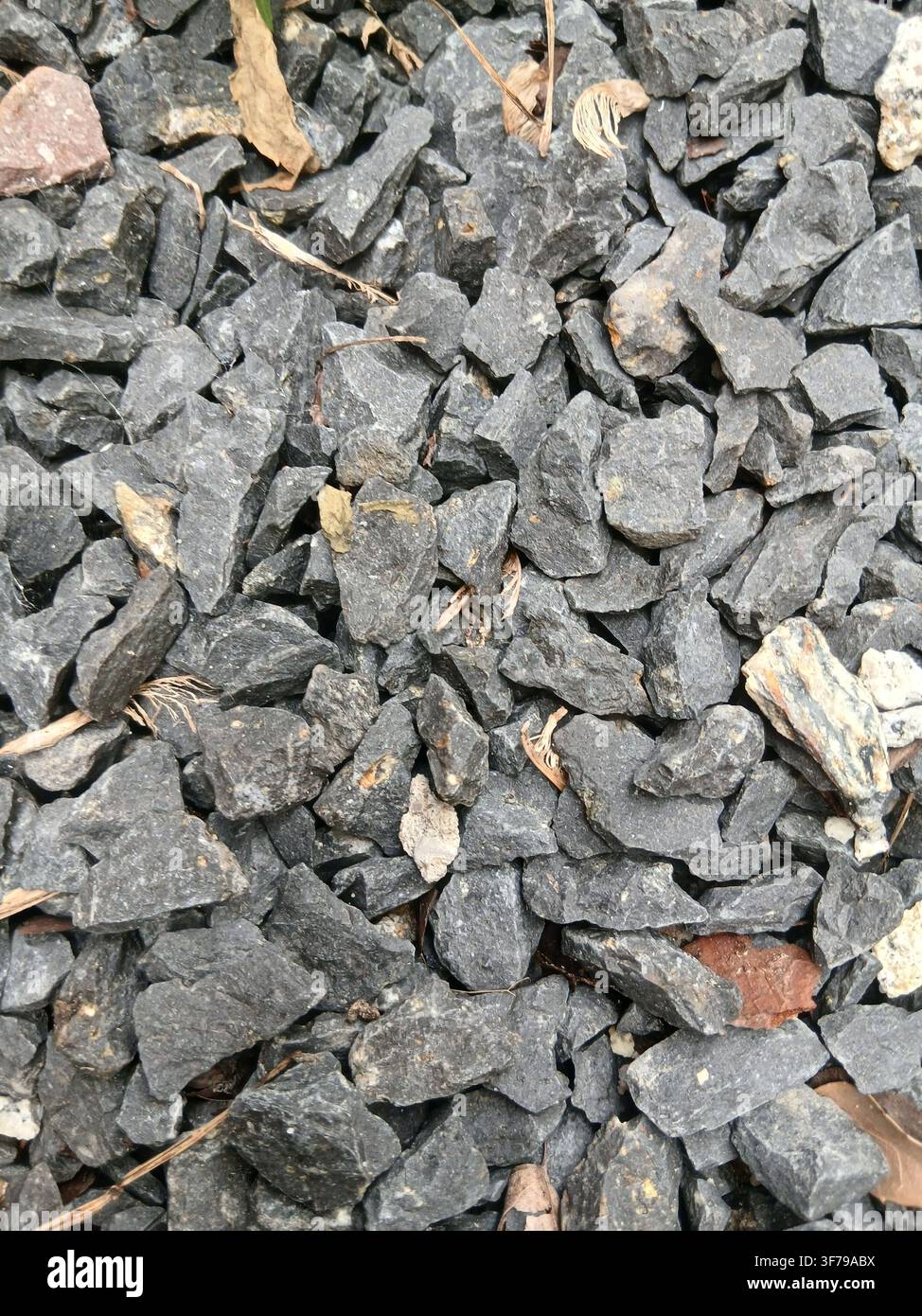 Graue zerkleinerte Granitkies- und Kleinstein-Hintergrundtextur. Oberansicht von sauberem natürlichem Schotter, Kieselsteinen und Sand für den Bau. - Smartphone-aufgenommenes Stockfoto
