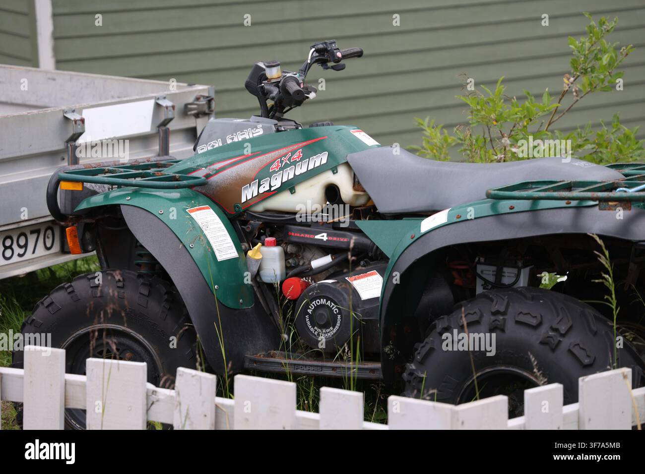 Vintage-ATV, das im Freien geparkt ist, zeigt ein robustes älteres Design und eine praktische Geländegängigkeit. Stockfoto