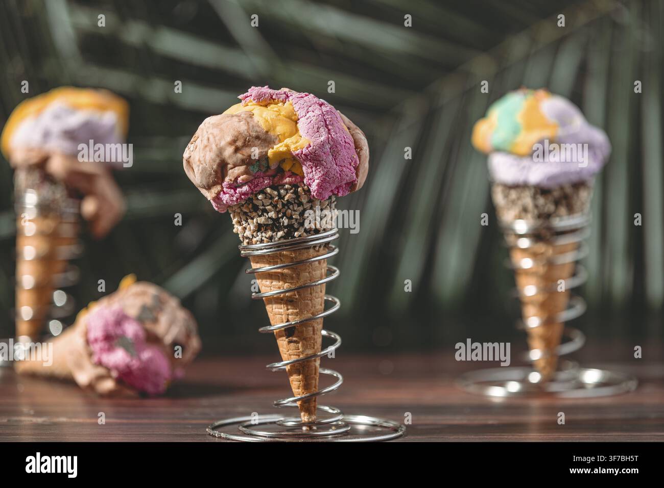 Drei Eiswaffeln mit farbenfrohem Eis in einer tropischen Umgebung Stockfoto