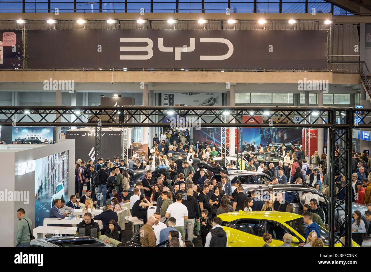 BELGRAD, SERBIEN - 22. MÄRZ 2026: Logo von BYD mit einer Menschenmenge potenzieller Kunden in ihrem Autohaus in Belgrad. BYD ist ein chinesischer Automobilhersteller, der Stockfoto