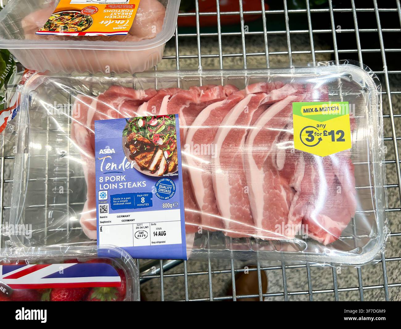Eine Packung Port-Loin-Koteletts in einem Supermarkt wird als Teil eines Mehrpacks angeboten, bei dem man einen Rabatt erhält, wenn man drei rabattierte Artikel kauft. - Smartphone-aufgenommenes Stockfoto