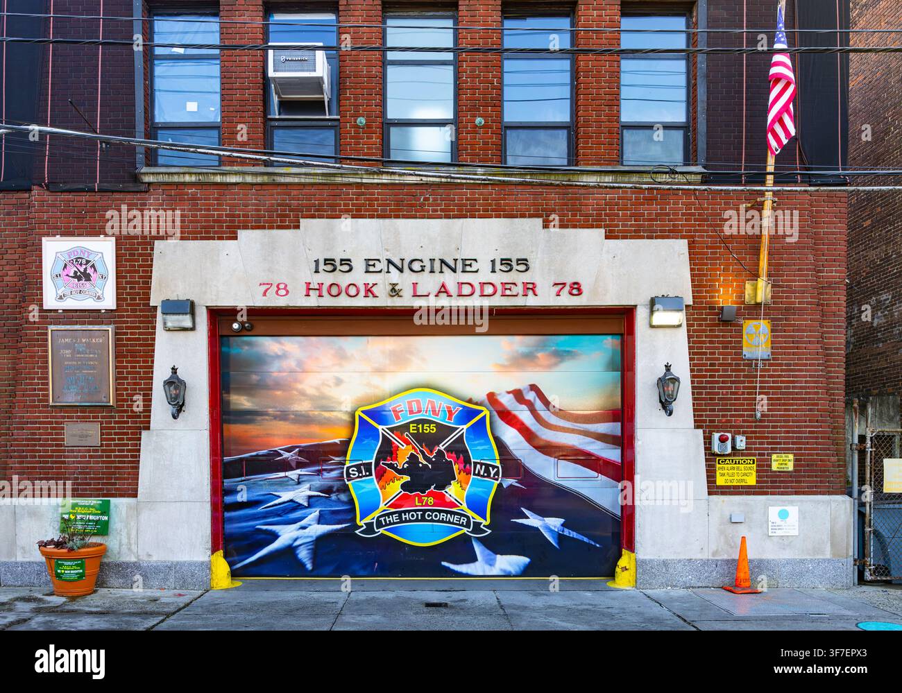 New York, USA - 20. Februar 2026: Historische Ziegelverkleidung des FDNY-Feuerwehrhauses Engine 155 und Hook and Ladder 78 mit einer bemalten Grafikgaragentür Stockfoto