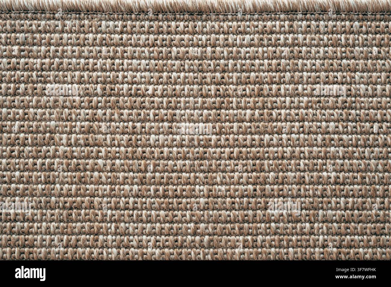 Oberansicht eines texturierten beigefarbenen Teppichs mit gewebtem Oberflächenmuster. Minimalistisches Wohninterieur, Bodenbelag und Textil-Hintergrundkonzept. Stockfoto
