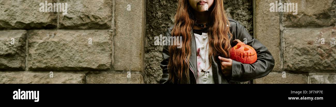 Kopfzeile von Mädchen hält geschnitzten Kürbis für Halloween Stockfoto