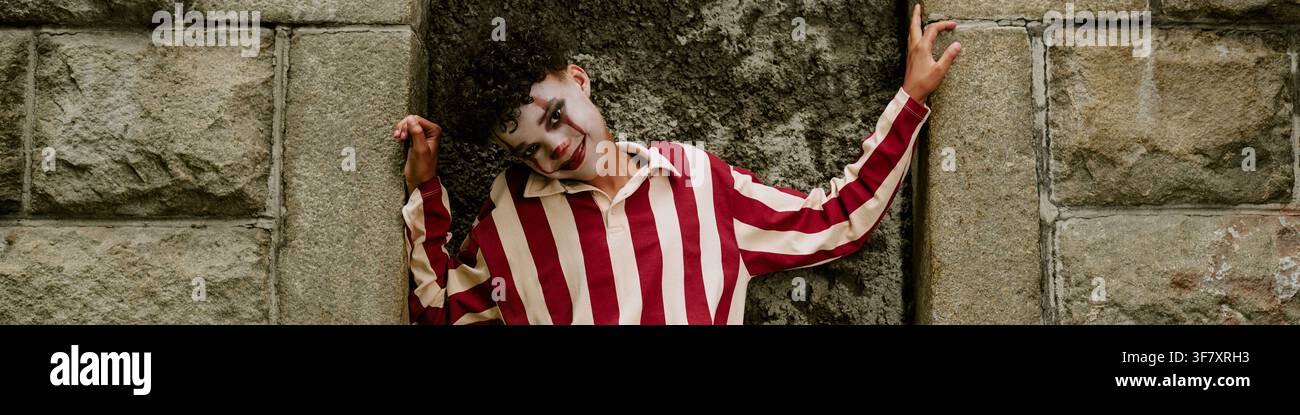 Kopfporträt eines afroamerikanischen Jungen mit Clown-Make-up, der Halloween feiert Stockfoto