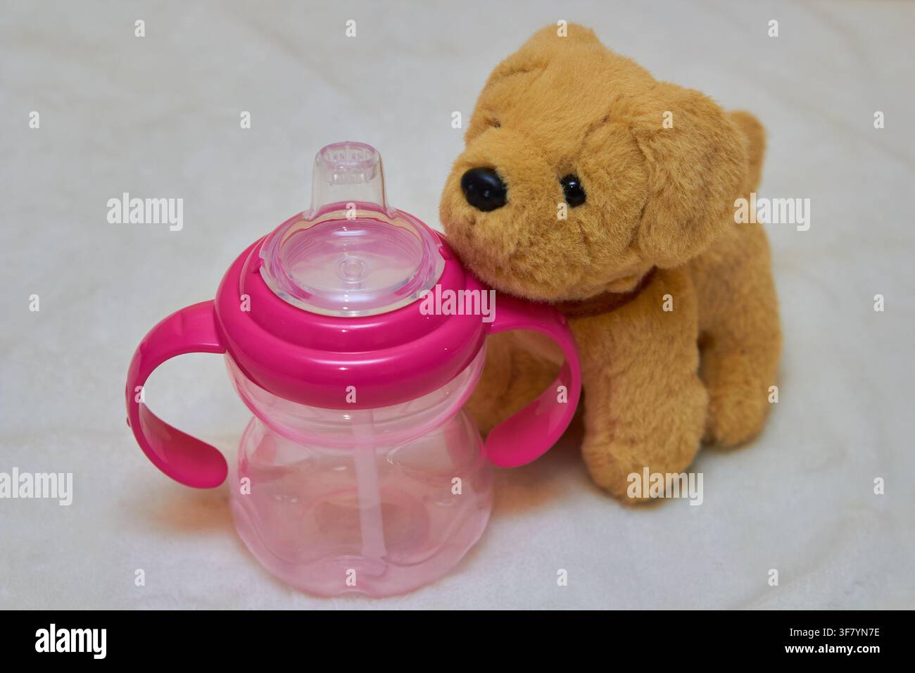 Plastik-Trinkflasche für Kinder mit einem Stofftier Stockfoto