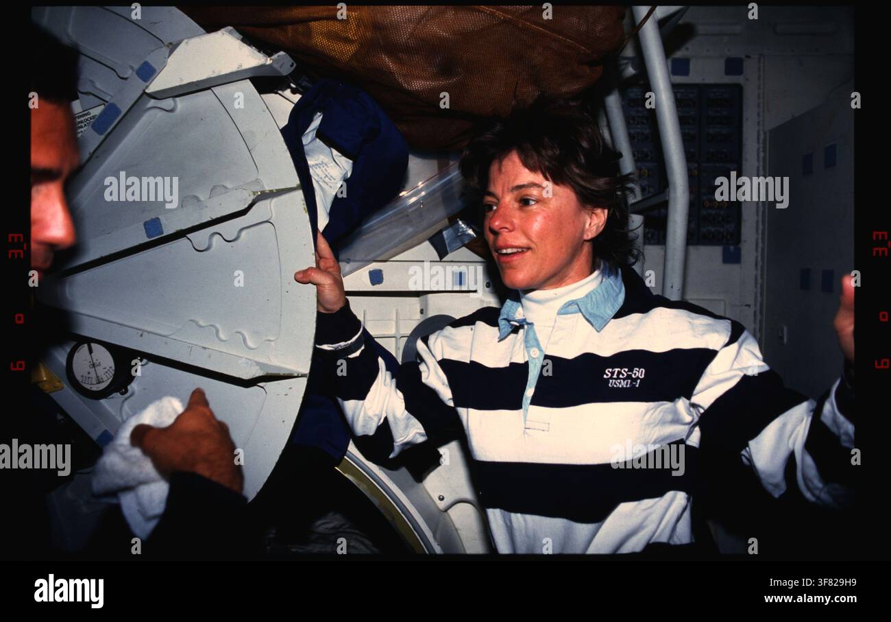 Ein Besatzungsmitglied der Space-Shuttle-Mission STS-050 zeigt auf ein Patch der University of Alabama at Birmingham (UAB) auf dem Mitteldeck. Stockfoto