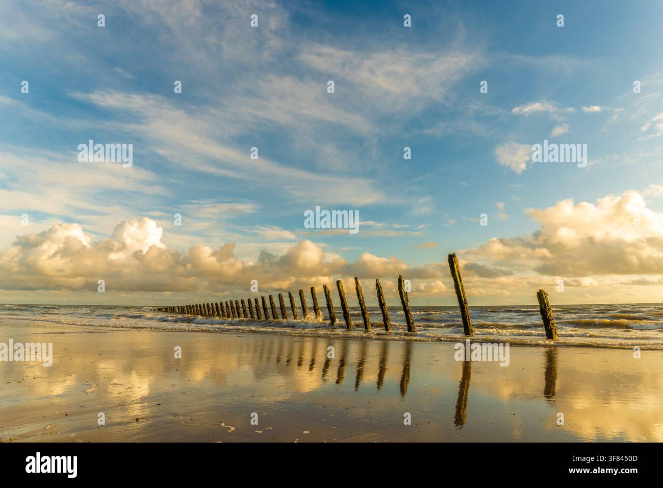 Sonnenlicht und Wolken spiegeln sich im Sand mit Meeresbrandung entlang der Küste von Walney Island auf der Furness-Halbinsel Stockfoto