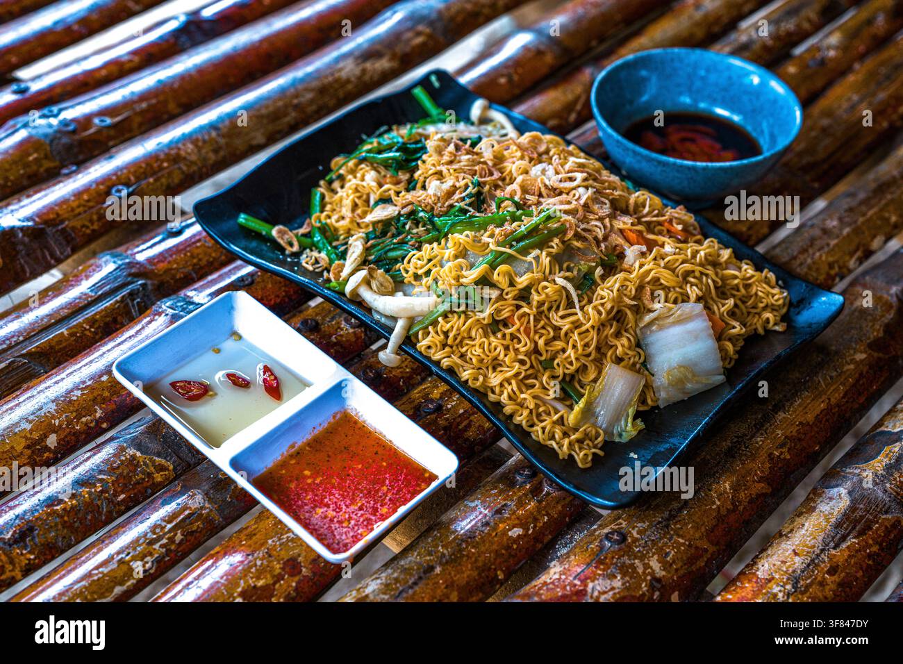 Köstliches Mi Xao Chay-Gericht, serviert mit Soßen in Vietnam, das lokale Aromen und vegetarische Optionen zeigt Stockfoto