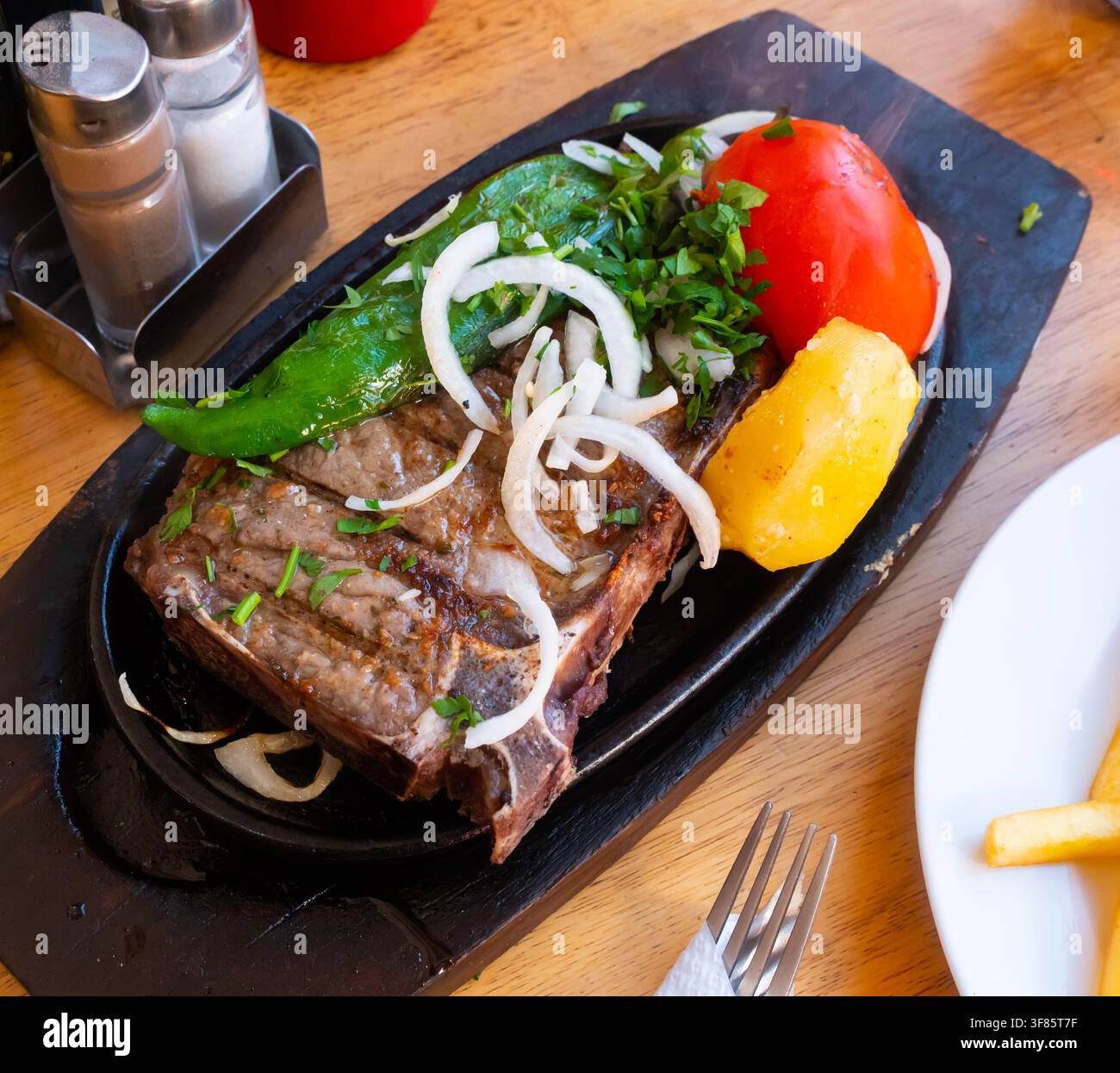 Mittelgeröstetes Entrecote garniert mit Salat aus frischem Gemüse Stockfoto