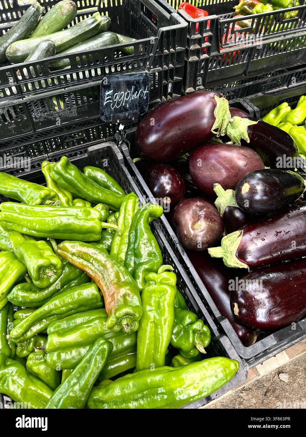 Eine Vielzahl von frisch gepflückten Gemüsen an einem Bauernstand, darunter Auberginen, Paprika und Zucchini. Stockfoto