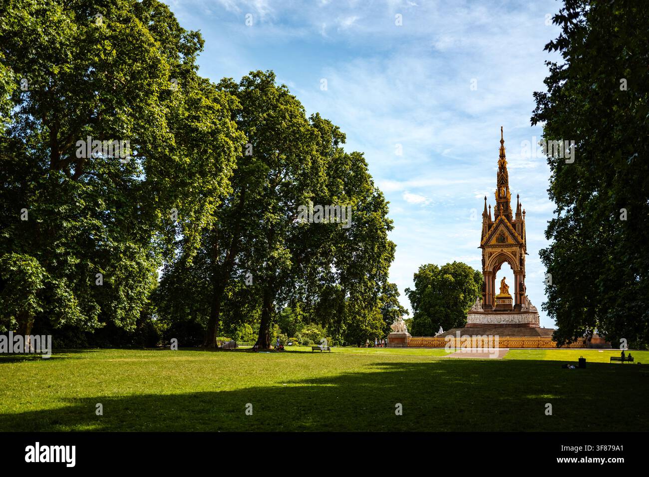 Albert Memorial, gesehen über die Rasenflächen und alten Bäume von Kensington Gardens in London an einem sonnigen Tag. Stockfoto
