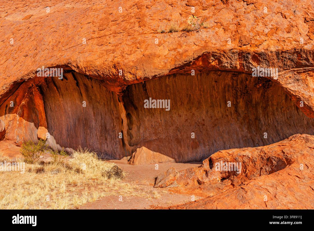 Outback, Australien - 15. April 2025: Höhle am Uluru Ayers Rock, Sandsteinmonolith, heilig für die Anangu im Herzen des Northern Territory’s Stockfoto
