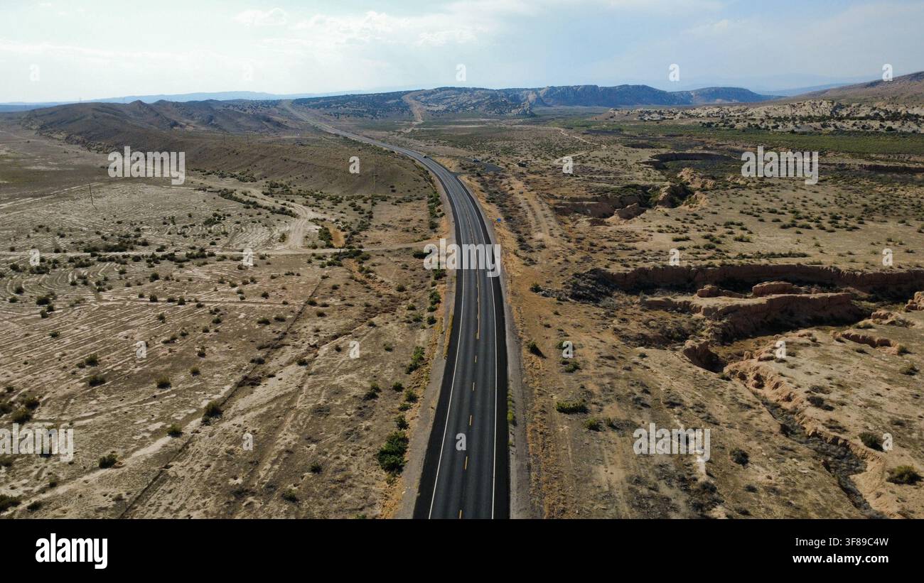Luftbilddrohnenaufnahme einer Autobahn, die eine trockene Wüstenlandschaft in Utah, USA, überquert.JPG Stockfoto