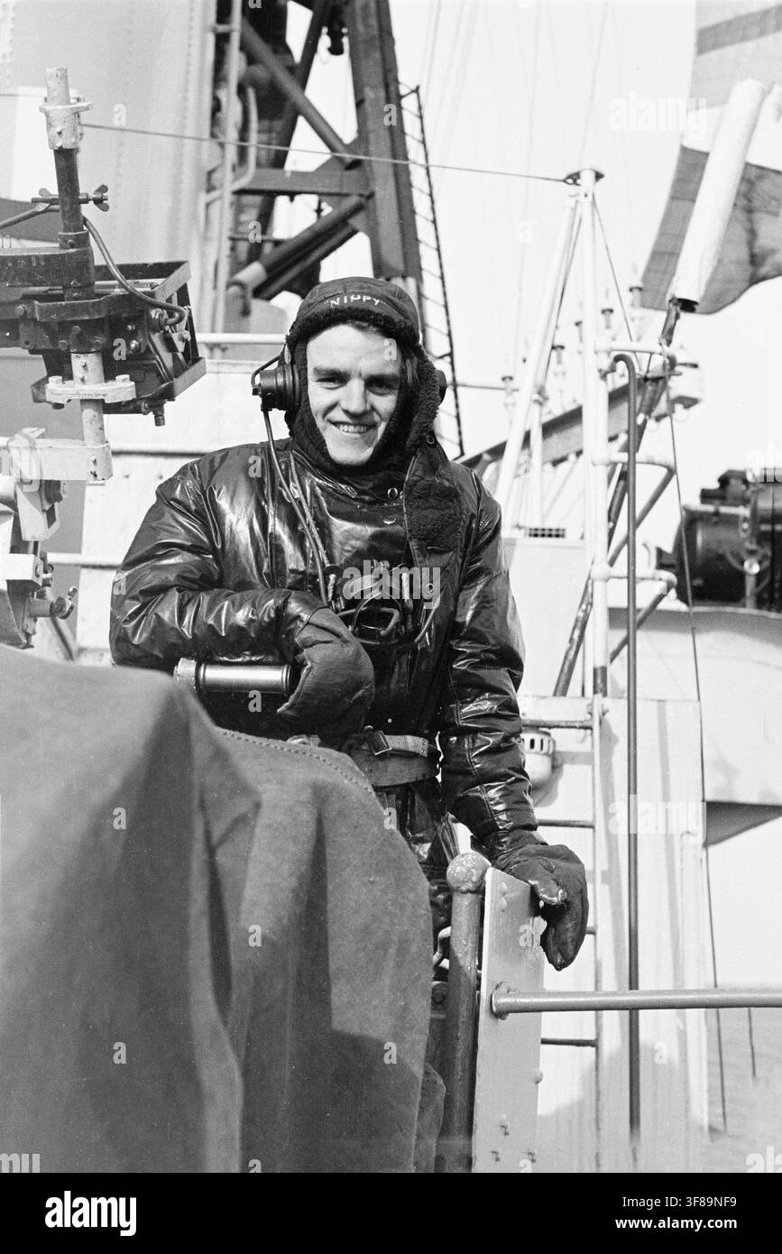 Besatzungsmitglied an Bord des Royal-Navy-Flugzeugträgers HMS Glory während des Einsatzes im Koreakrieg 1952. Kaltwettersmütze, Handschuhe und Kopfbedeckung. Kopfhörer und Spitzname „Nippy“ auf der Mütze. Möglicherweise ein Schütze Stockfoto