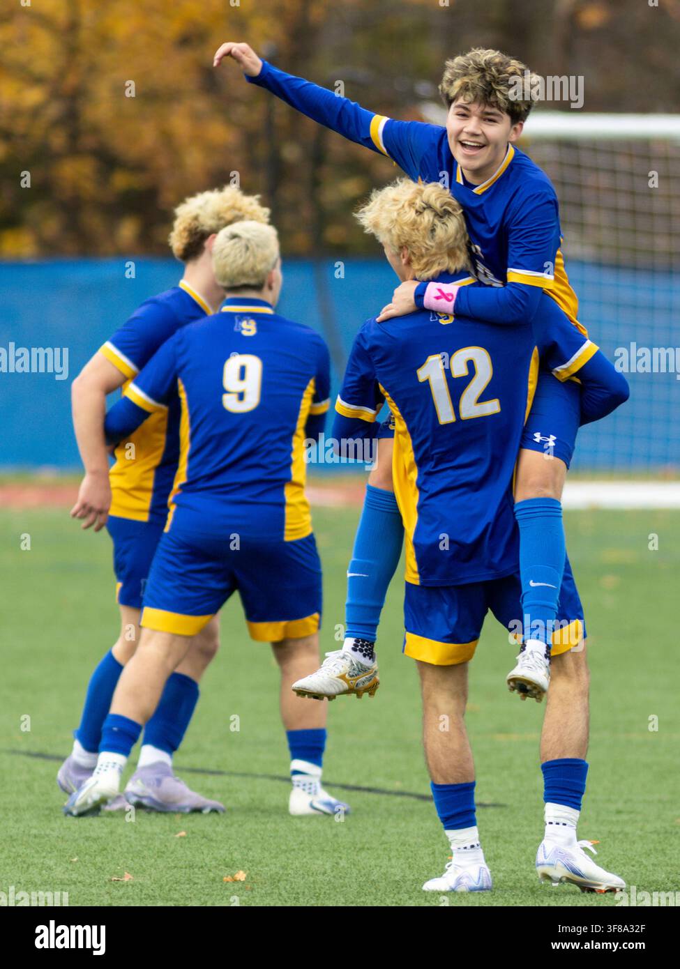 Ein Spieler feiert mit seinem Mannschaftskollegen, nachdem er während eines Halbfinalspiels bei den New York State Jungenfußballmeisterschaften ein Tor erzielt hat. Stockfoto