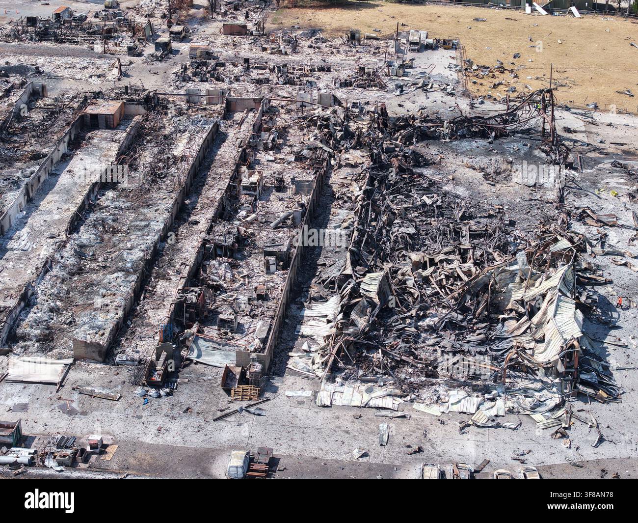 Nachwirkungen eines Brandes auf der Highlands Farm in Rettendon, Essex, mit umfangreichen Schäden an Gebäuden, ausgebrannten Fahrzeugen und Trümmern, 11. August 2026. Stockfoto