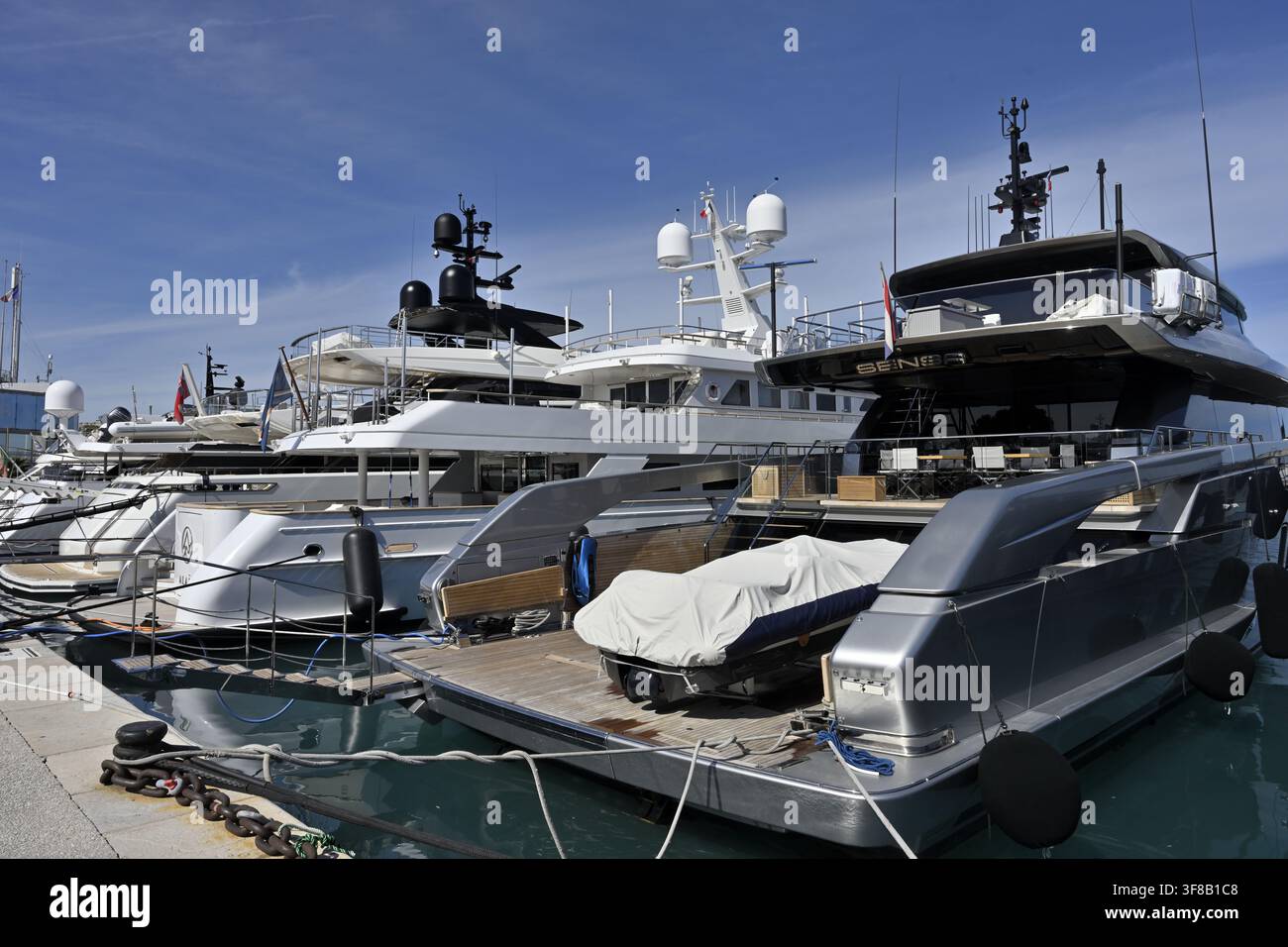 Antibes Marina Heck von vertäuten Yachten, eine mit einem Motorboot auf dem Heckdeck, Antibes Frankreich Stockfoto
