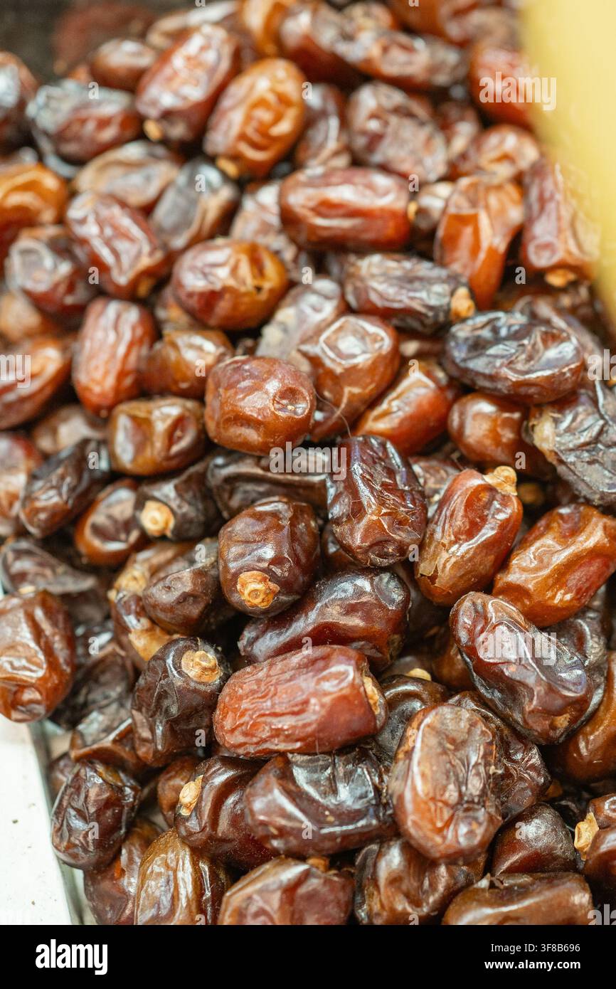 Nahaufnahme-Muster von süßen braunen getrockneten Datteln, reich an Energie und natürlichen Zuckern. Toller visueller Inhalt für orientalische Lebensmittelmärkte, Iftar zur Fastenbrechenzeit Stockfoto
