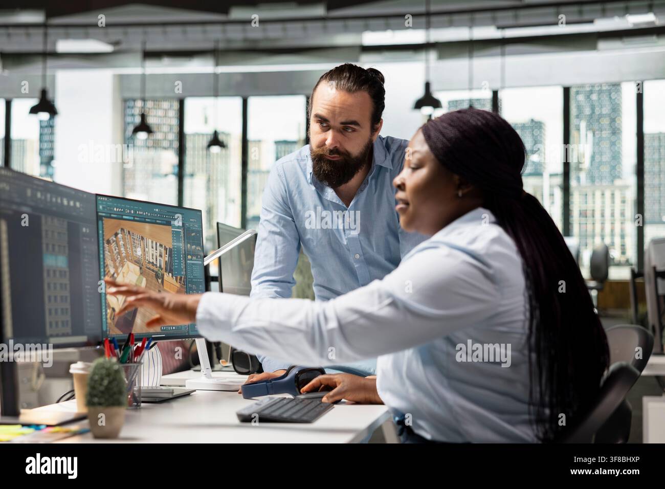 Architekturteam verwendet professionelle CAD-Werkzeuge und Render-Software zur Gestaltung eines modernen Wohnraumlayouts. Diverses Personal arbeitet am PC an der Erstellung von 3D-Modellierungsassets, Bauplänen. Stockfoto