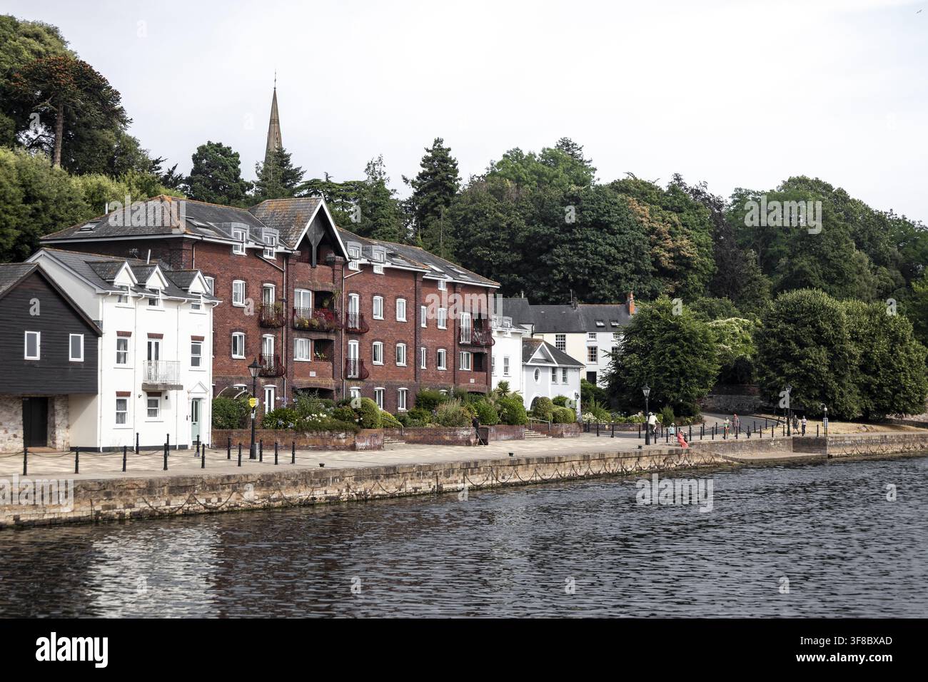 Blick auf die historischen Flussufergebäude mit roten Ziegelfassaden und einem weißen Haus entlang der Exe-Fluss-Promenade in Exeter, England, Vereinigtes Königreich. Stockfoto
