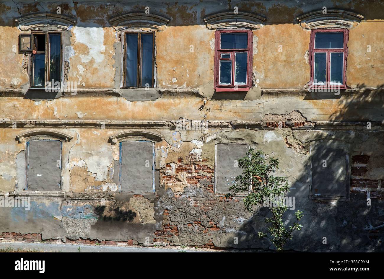 Ein altes verfallenes Haus. Die Fenster des ersten Stocks sind zugemauert. Im zweiten Stockwerk gibt es alte Holzfenster. Stockfoto