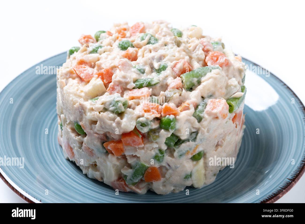 Traditioneller russischer Salat mit Thunfisch und Gemüse isoliert auf weißem Hintergrund Stockfoto