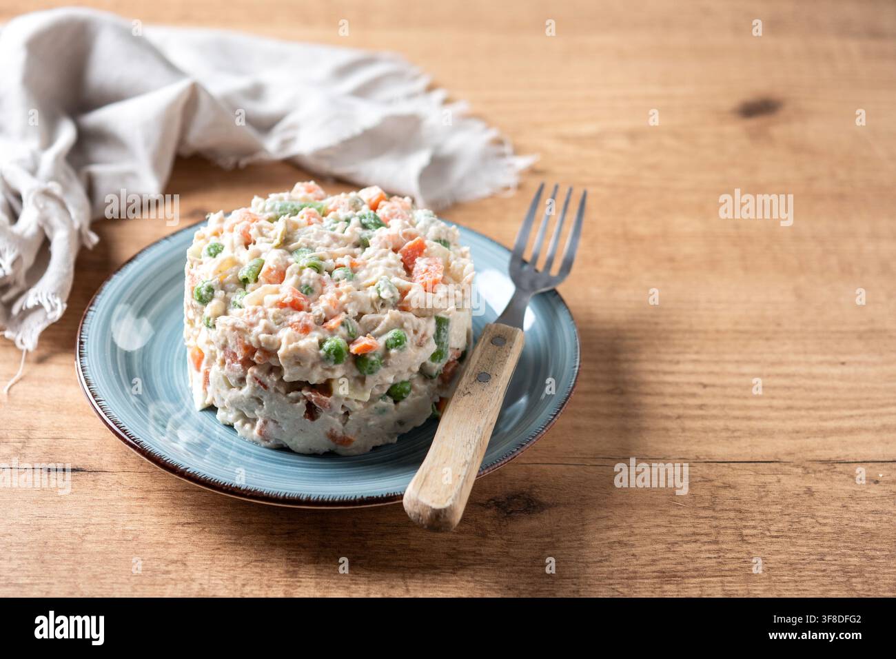 Traditioneller russischer Salat mit Thunfisch und Gemüse auf Holztablett Stockfoto