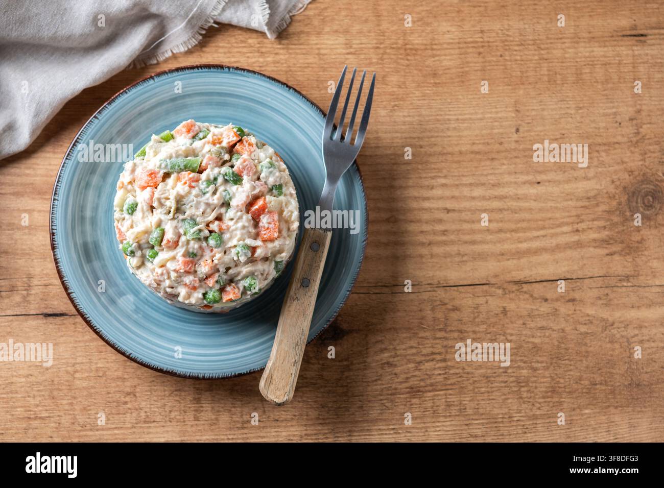 Traditioneller russischer Salat mit Thunfisch und Gemüse auf Holztablett Stockfoto