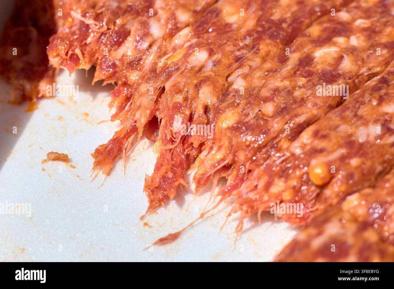 Nahaufnahme von rohen rumänischen Mici, traditionellen enthäuteten Hackfleischröllchen, die zum Grillen zubereitet sind, mit Knoblauch und Gewürzen gewürzt, bereit für den Grill i Stockfoto