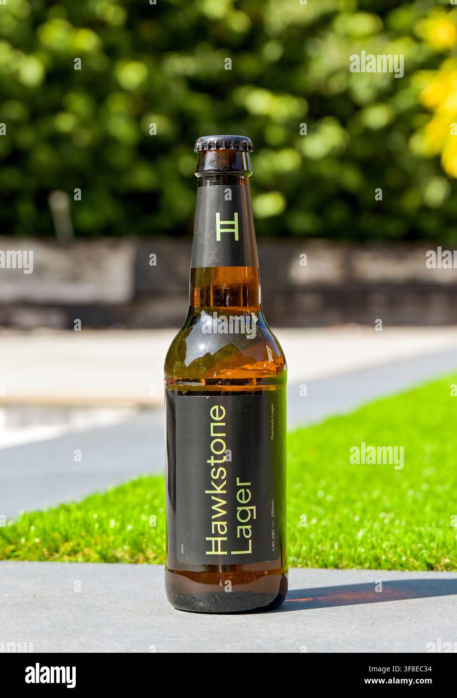 Cardiff, Wales, UK - 9. August 2026: Ungeöffnete Flasche gekühlten Harkstone Lager isoliert an der Wand einer Gartenterrasse. Stockfoto