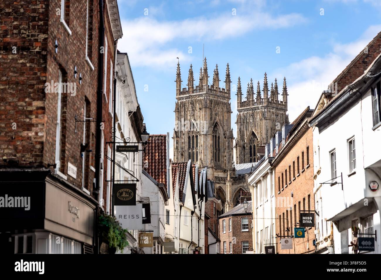 York, England, Vereinigtes Königreich - 18. Juli 2026: Blick entlang einer historischen Einkaufsstraße in Richtung der beiden westlichen Türme des York Minster Stockfoto
