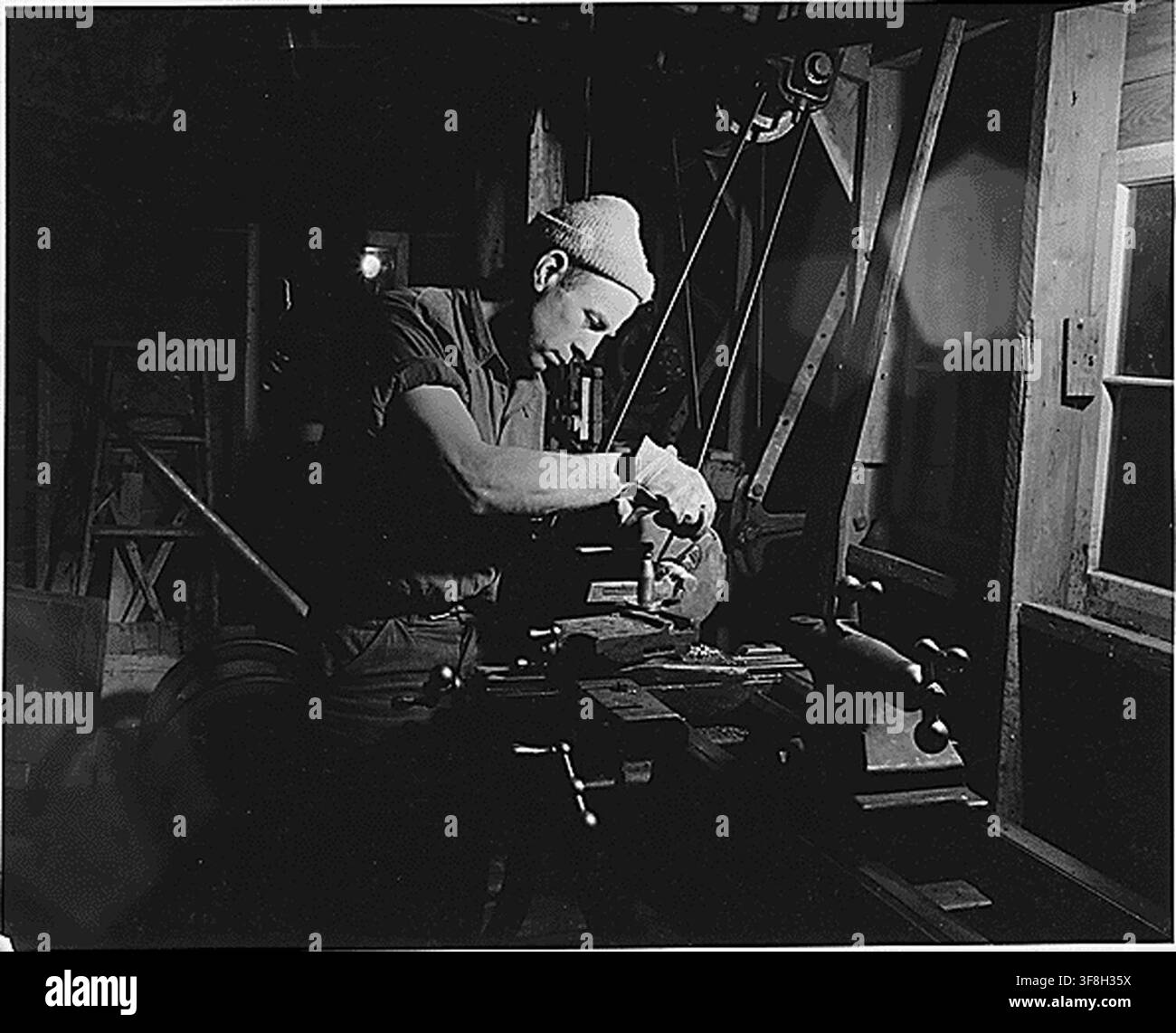 Ein junger Bauer arbeitet an einer Drehmaschine in einer Maschinenwerkstatt in Sublette, Haskell County, Kansas, April 1941, wo örtliche Bauern, die in Mechanik geschult sind, verschiedene mechanische Arbeiten übernehmen, einschließlich derer, die während der Erntezeit erforderlich sind. Stockfoto