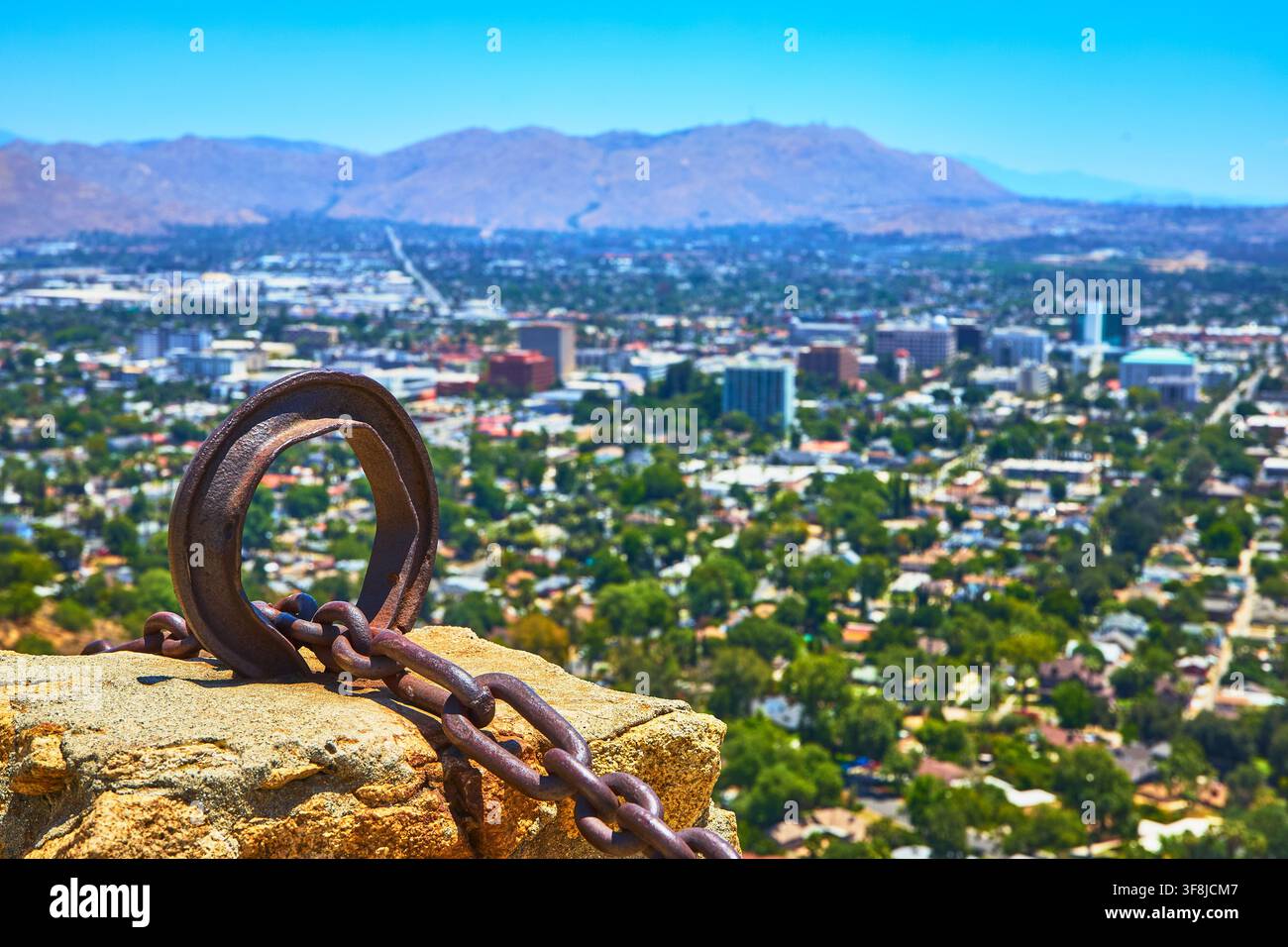 Mt Rubidoux Eisenring mit Kette mit Blick auf die Stadtsilhouette von Riverside und die fernen Berge Stockfoto