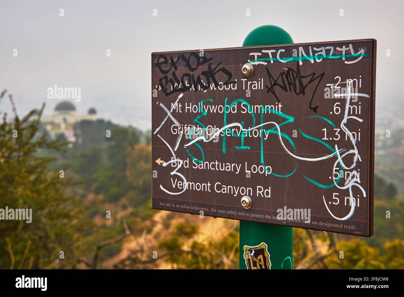 Wegweiser im Griffith Park mit Graffiti und Observatorium in Los Angeles, Kalifornien Stockfoto
