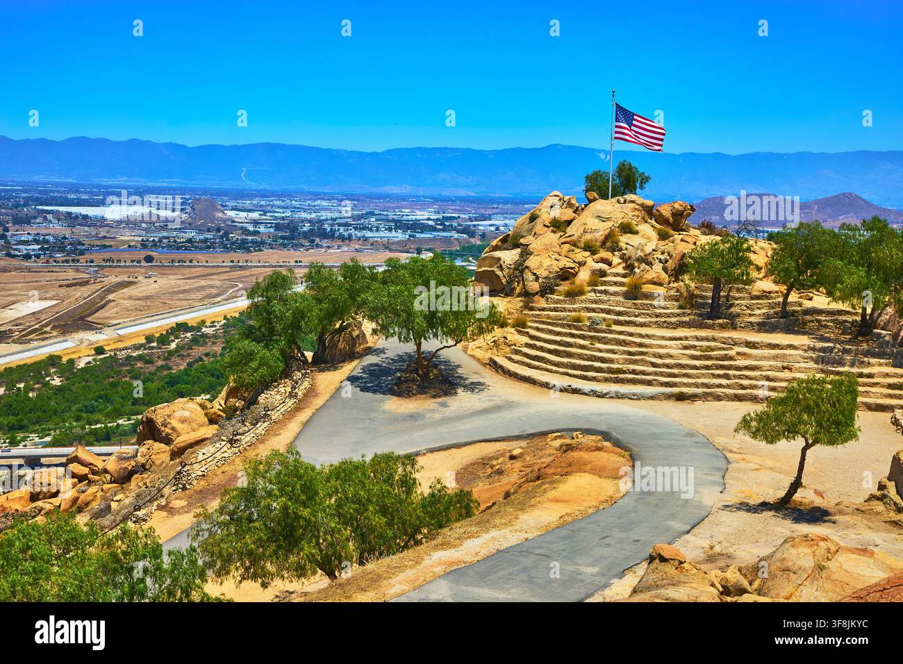 Amerikanische Flagge auf dem felsigen Gipfel des Mt Rubidoux Pfades mit malerischem San Bernardino Tal Stockfoto
