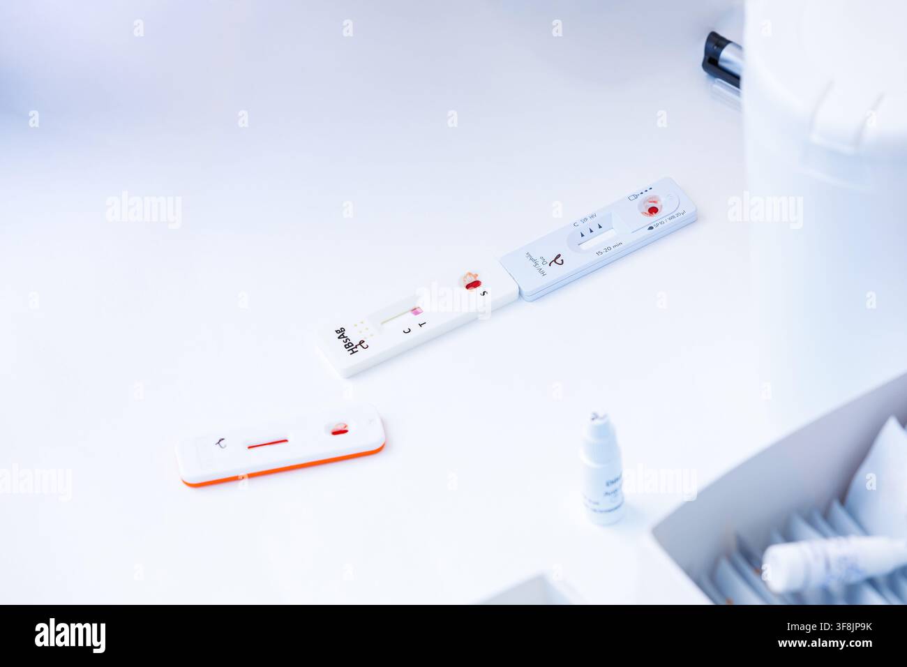 Schnelltest-Kassetten mit Blutproben für HIV-, Syphilis- und Hepatitis-B-Diagnose auf einem weißen Medizintisch in einem klinischen Labor. Stockfoto