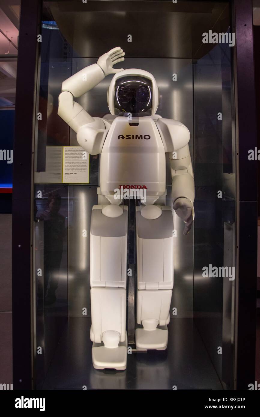 Honda ASIMO Humanoider Roboter steht mit erhobener Hand in einer Glasvitrine. Stockfoto