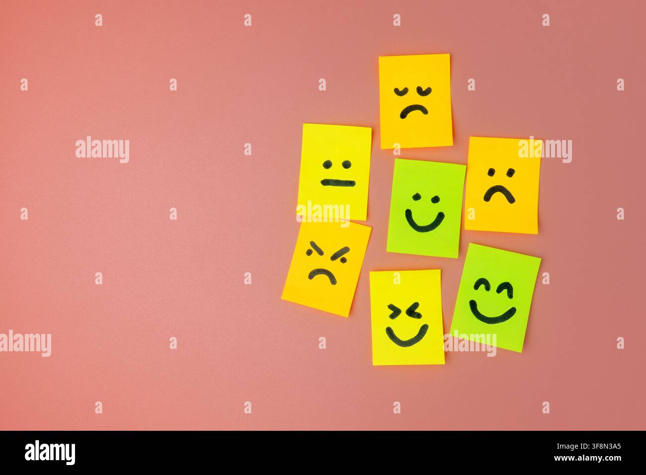 Bunte Haftnotizen mit gezeichneten Emoticon-Gesichtern, die verschiedene Emotionen auf einem rosa Hintergrund ausdrücken. Kundenfeedback, psychische Gesundheit, Bewertung, Rezension Stockfoto