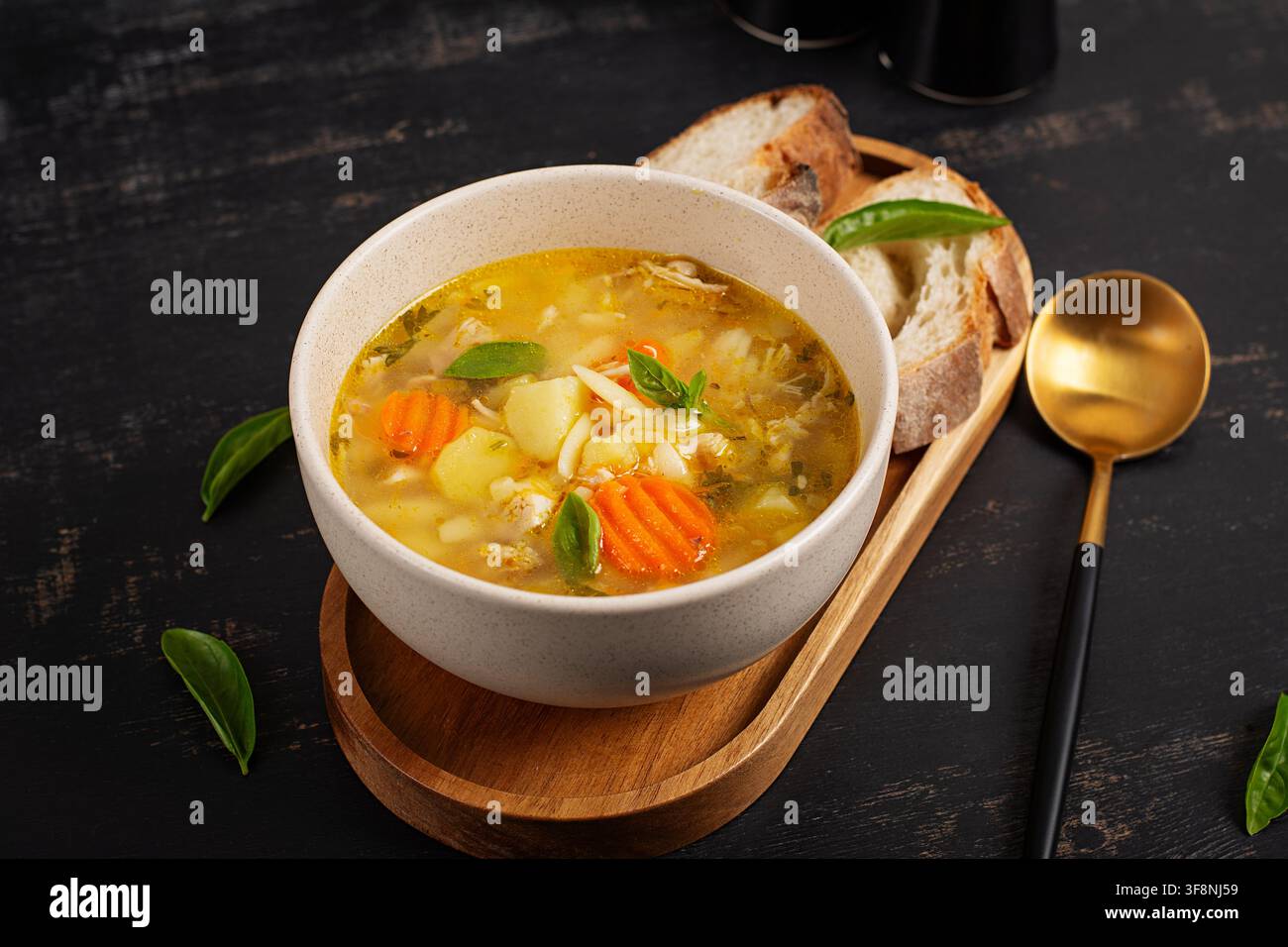 Nährender Hühnerbrühe mit Orzo-Pasta und frischem Basilikum Stockfoto