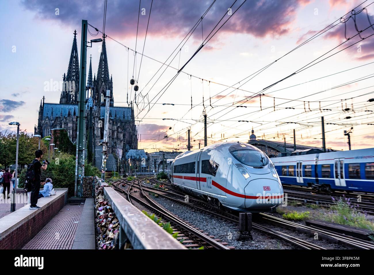 Die Hohenzollernbrücke über den Rhein, Eisenbahnbrücke, ein ICE-Zug, der den Hauptbahnhof verlässt und nach Osten fährt, Kölner Dom, Nordrhein-Westfalen Stockfoto