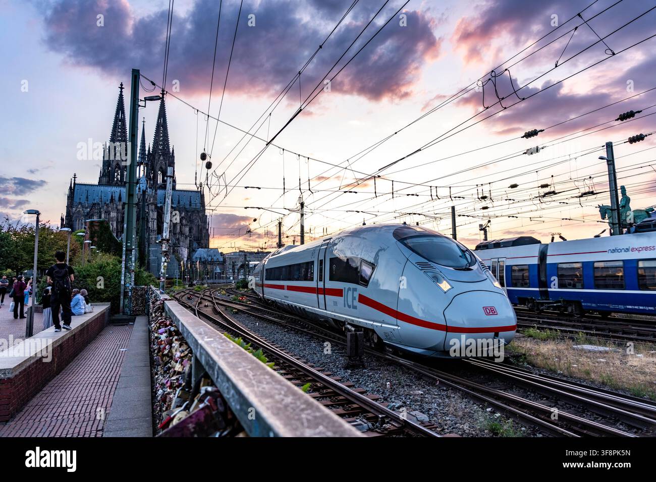 Die Hohenzollernbrücke über den Rhein, Eisenbahnbrücke, ein ICE-Zug, der den Hauptbahnhof verlässt und nach Osten fährt, Kölner Dom, Nordrhein-Westfalen Stockfoto