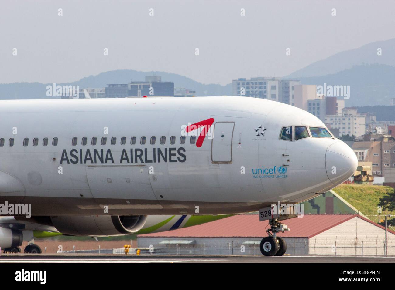 Nahaufnahme der Nase einer Asiana Airlines Boeing 767-300 (HL7528) mit dem Luftlinienlogo, Star Alliance und UNICEF-Emblem. Stockfoto