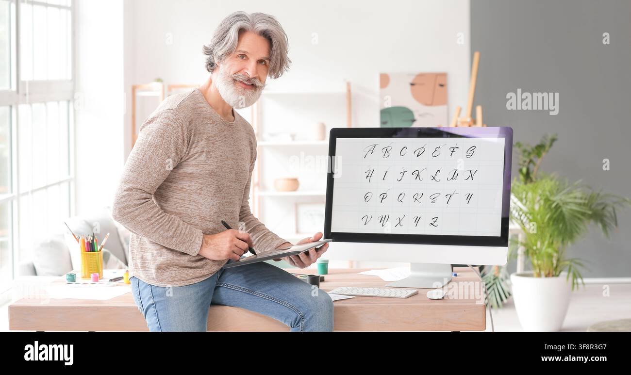 Lächelnder Senior mit grauen Haaren und Bart, der ein Grafiktablett für Kalligrafie-Design auf einem Computermonitor verwendet, Er ist in ein kreatives Hobby vertieft oder Stockfoto