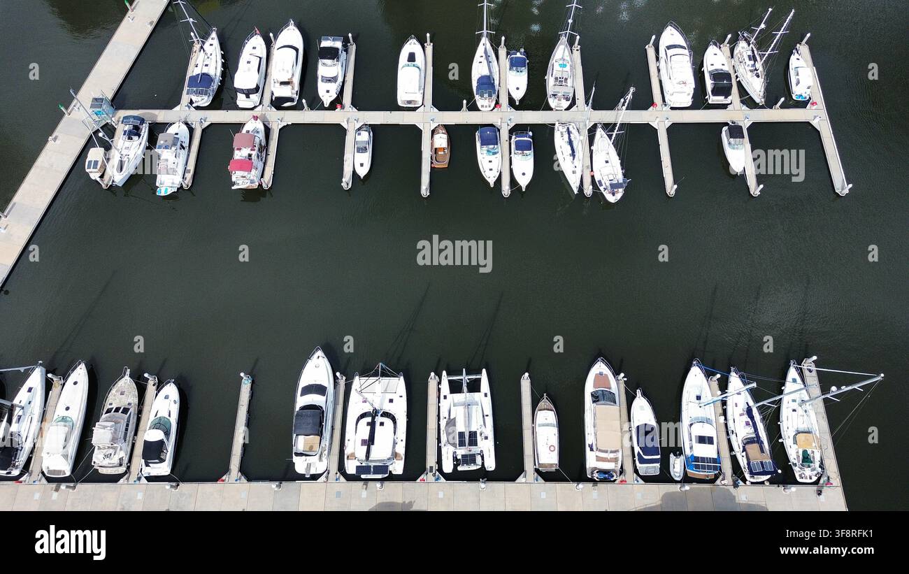 Top-Down-Luftaufnahme einer Marina mit vertäuten Booten und Yachten in symmetrischen Reihen Stockfoto