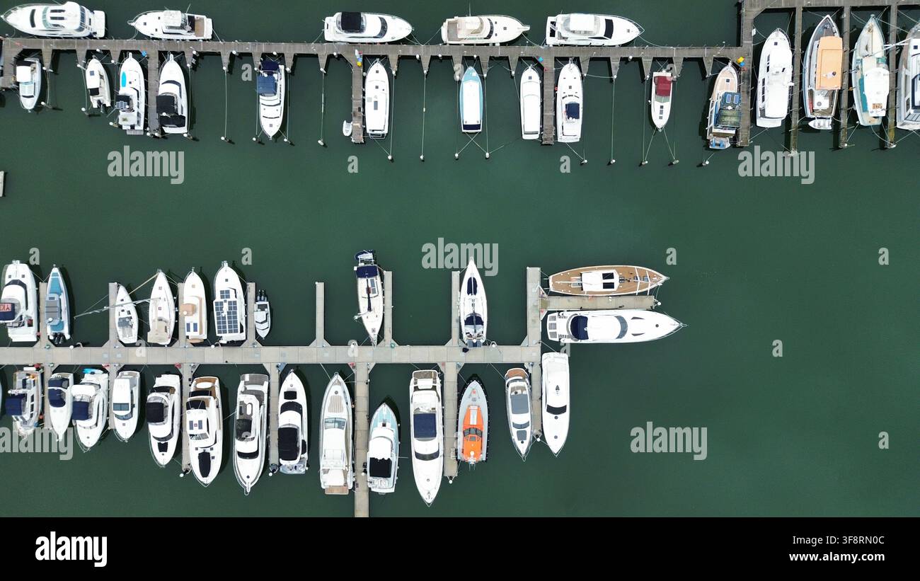 Boote und Yachten, die in einer belebten Marina vertäut sind, gesehen aus einer Luftansicht von oben, repräsentierend maritime Freizeit und Transport Stockfoto