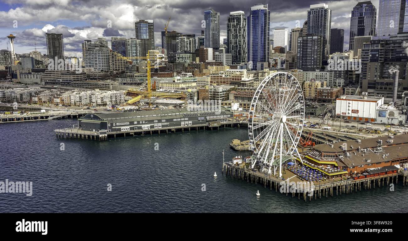 Luftbild des Seattle Great Wheel und des Space Needle, die über der Innenstadt-Skyline aufragen, mit Uferpiers und urbanem Bauwesen in Seattle, Wa Stockfoto