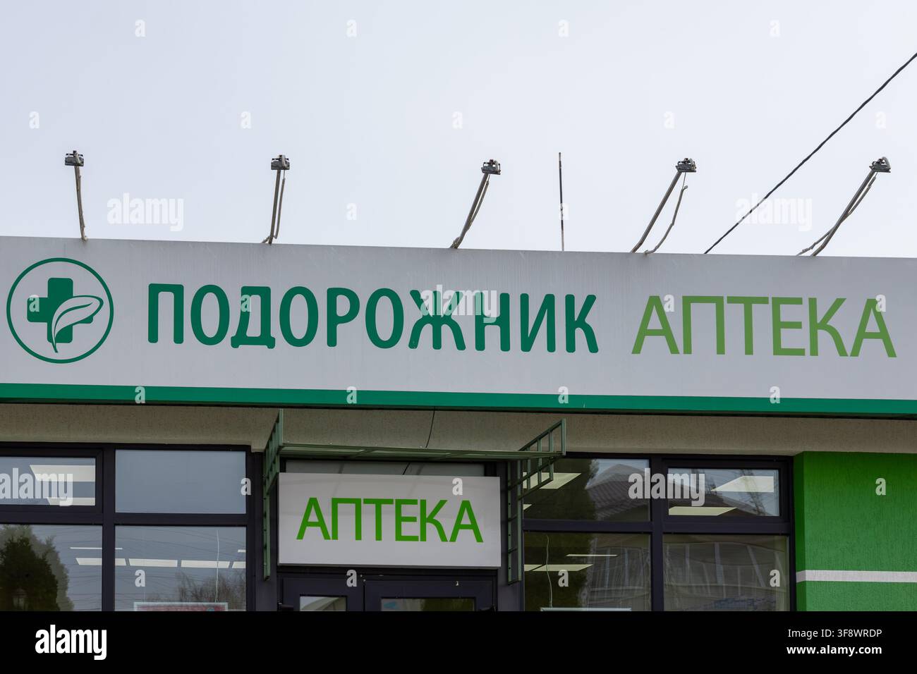 Horodok, Ukraine – 23. März 2026: Ein grünes Schild der Apotheke Podorozhnik mit einem medizinischen Kreuzsymbol, das den professionellen Gesundheits-Einzelhandel repräsentiert, Stockfoto