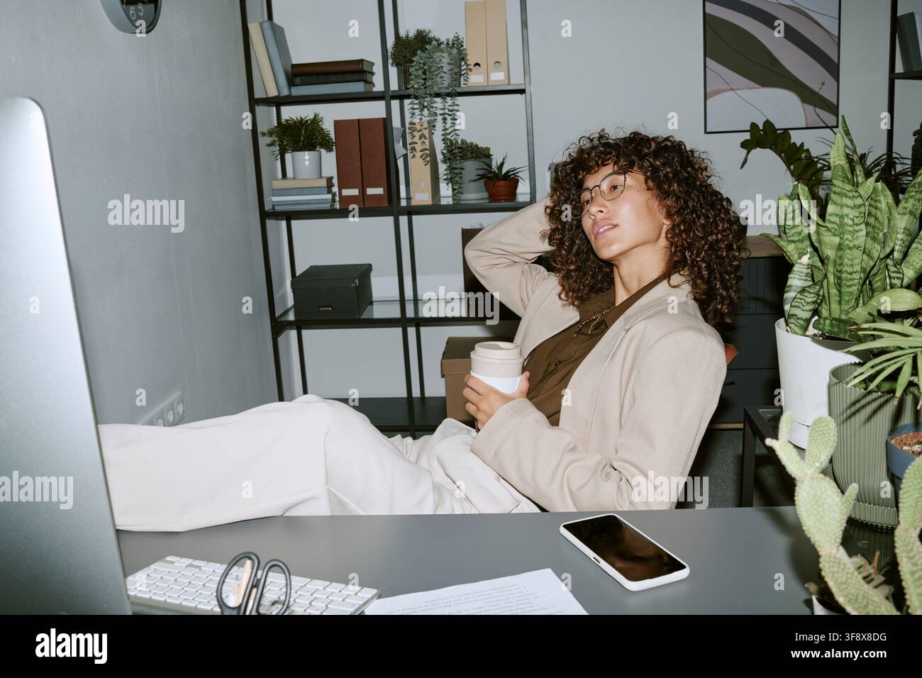 Geschäftsfrau entspannt am Schreibtisch in einem modernen Büro Stockfoto